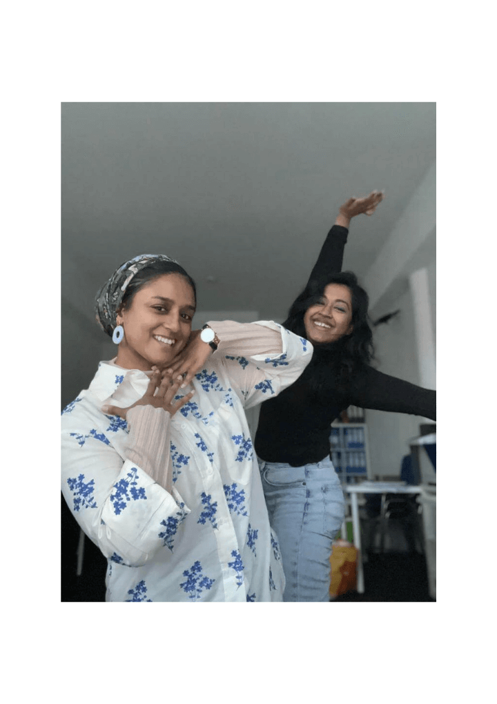 Two young women posing and smiling directly to camera.